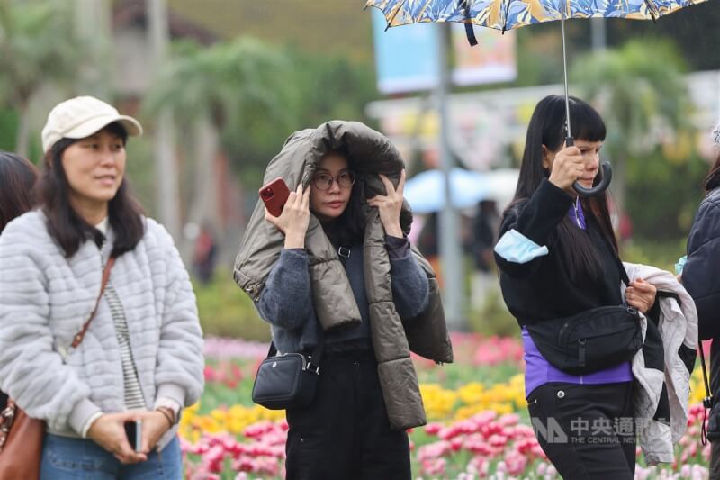 圖為遊客前往士林官邸，以衣物遮擋細雨。（中央社檔案照片）