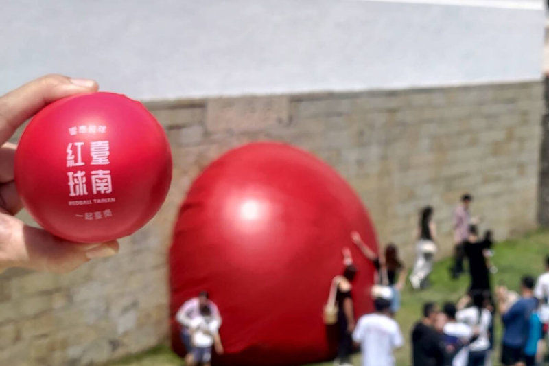 國際性裝置藝術行動「紅球計畫」造訪台南掀起熱潮，台南市政府獲藝術家授權推出限量紅球紀念品，在紅球此次未造訪場域推出互動遊戲贈送。（台南市文化局提供）中央社記者楊思瑞台南傳真 113年4月8日