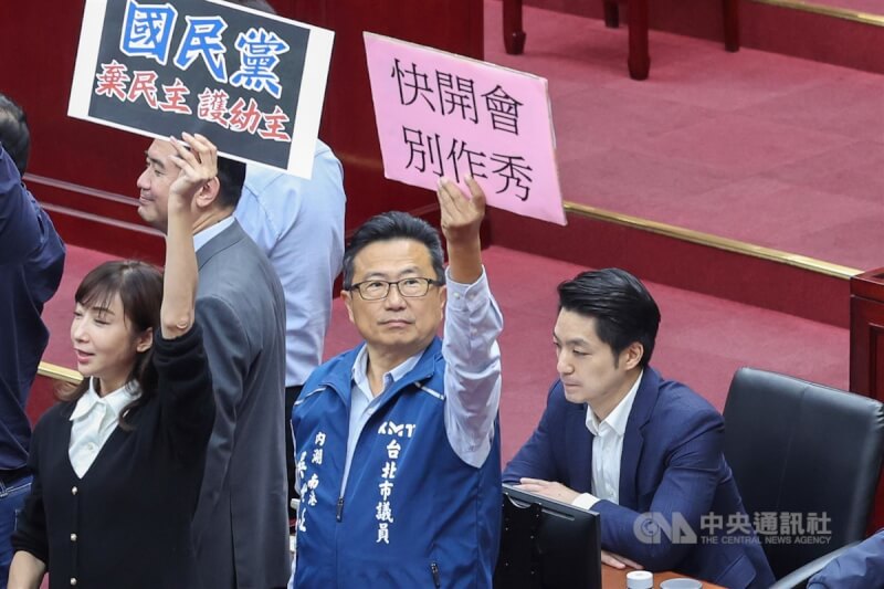 台北市長蔣萬安（右）9日赴議會施政報告，民進黨團在會前提權宜問題發言批評蔣萬安別躲在國民黨團背後，民進黨議員拿出「棄民主、護幼主」紙板到蔣萬安位置抗議，國民黨團見狀，也拿出「快開會、別作秀、要監督、反口水」紙板反制。中央社記者吳家昇攝 113年4月9日