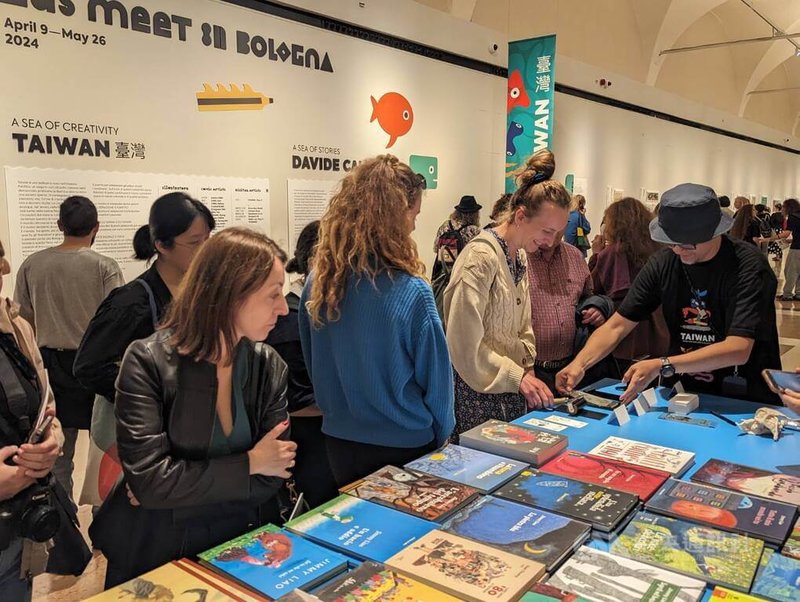 「當兩個海洋相會在波隆那」特展於義大利當地時間9日晚間盛大開幕,台灣插畫家Croter(洪添賢)(右戴帽者)現場教導參觀者印版手工上色。中央社記者王寶兒攝 113年4月10日
