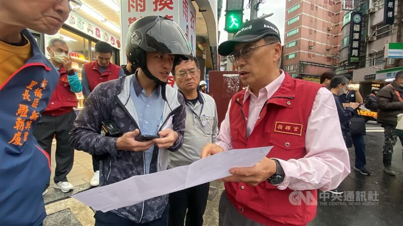 板橋區長陳奇正(前右)到場坐鎮指揮,拿出圖面確認現場瓦斯管線位置。中央社記者黃旭昇新北市攝 113年4月10日