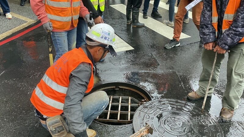 工程人員打開下水道孔確認水流是否順利停止。中央社記者黃旭昇新北市攝 113年4月10日