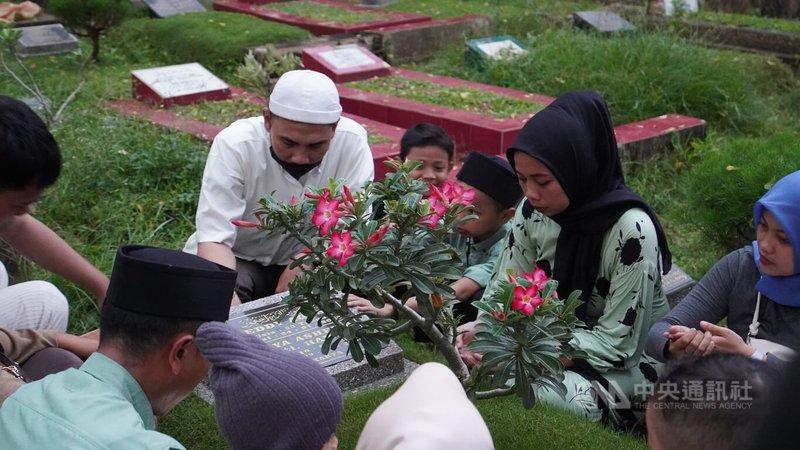 家庭成員超過12人的印尼穆斯林艾米爾一家人，在開齋節到墓園為死去的父母祈禱。中央社記者李宗憲雅加達攝  113年4月10日
