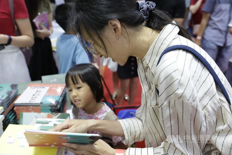 第18届马来西亚海外华文书市受到星马读者青睐，图为母亲引导女儿阅读绘本。中央社记者黄自强吉隆坡摄  113年4月11日