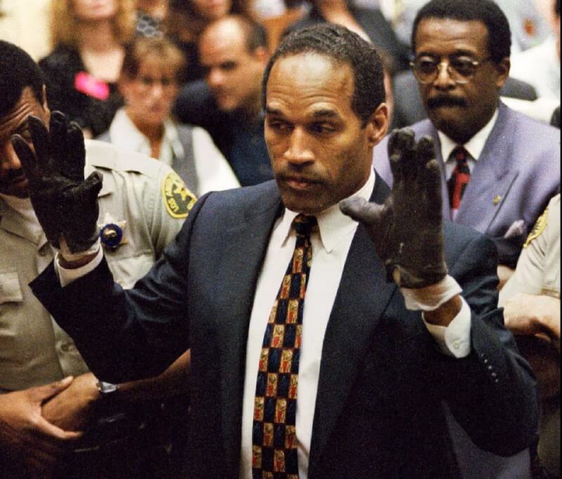 在1995年的法庭審判中，辛普森在檢察官要求下向陪審團展示他戴上在犯案現場被發現、沾上血跡的證物手套的樣子。（路透社）