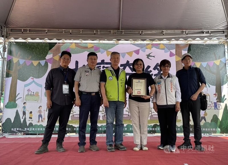 澎湖縣政府等單位13日在馬公五德社區舉辦植樹活動,澎縣府由秘書長蔡淇賢(前左3)代表,與慈心有機農業發展基金會總監程禮怡(前右3)簽署合作備忘錄,並致贈感謝狀,感謝基金會多年來協助地方造林植樹。中央社 113年4月13日
