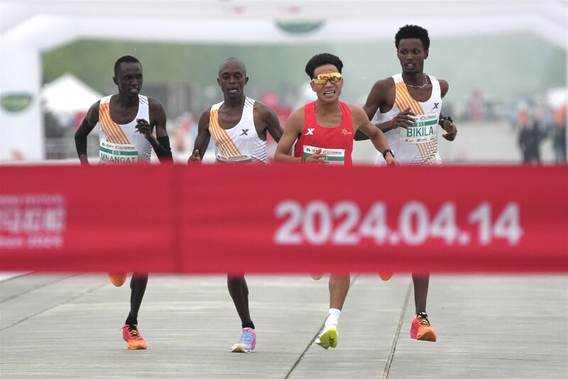 2024年北京半程馬拉松賽14日舉行，男子組中國選手何杰（前）疑似在3名非洲選手放水下奪冠引發質疑。（中新社）