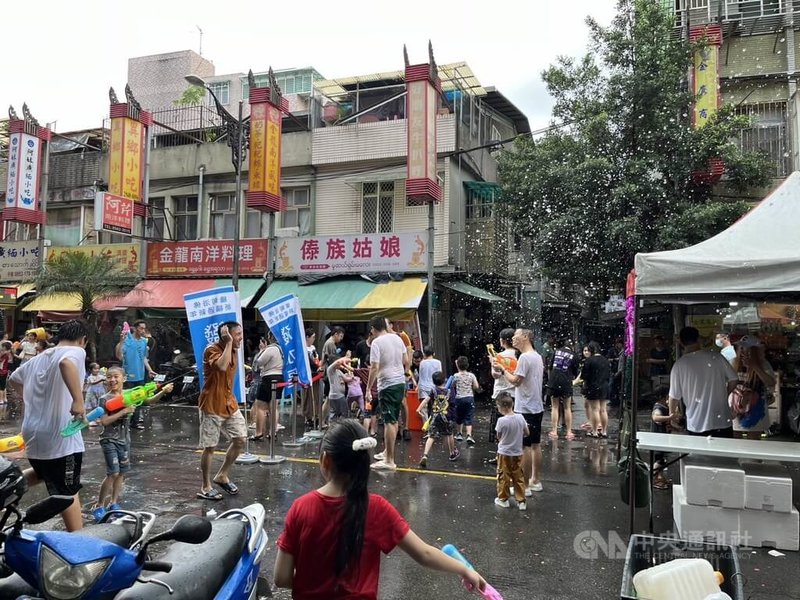 2024緬甸新年浴佛活動21日在新北市中和區華新街封街舉行，大人與小孩都拿出水槍玩水，相當熱鬧。中央社記者高華謙攝 113年4月21日