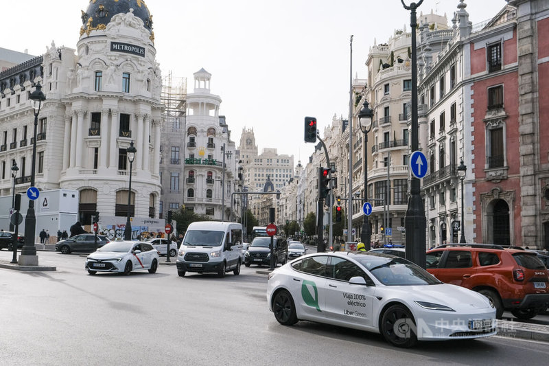 西班牙首都馬德里為實現永續交通並減少碳排，啟動「改變360」（Cambia 360） 計劃，祭出汰舊換新電動車優惠補助方案，鼓勵市民淘汰老車並選購節能車款，促進城市運具電動化。圖為自格蘭大道駛出的Uber電動車。中央社記者胡家綺馬德里攝  113年4月25日