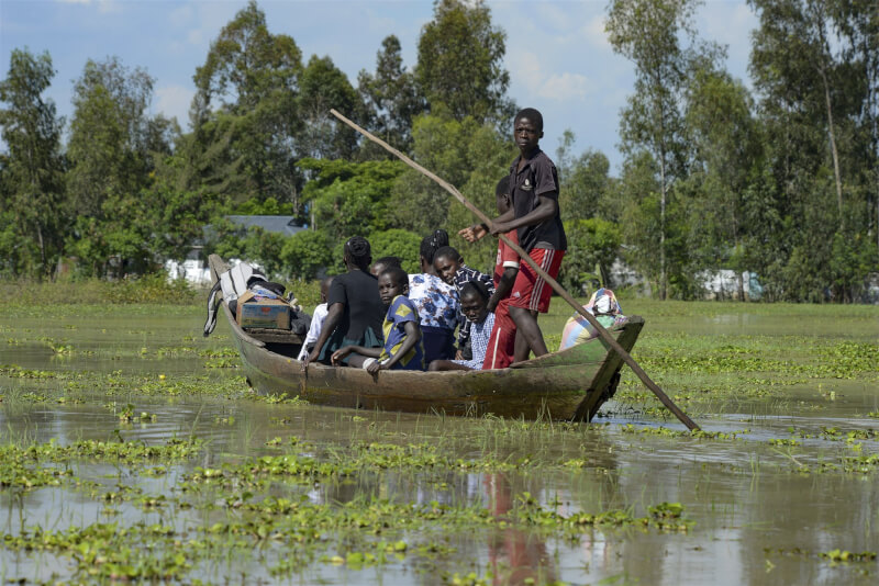 聖嬰現象常對非洲東部造成極大破壞，肯亞首都奈洛比本週遭突發性洪水衝擊，13人死亡。圖為肯亞一個家庭搭上獨木舟逃離洪水。（美聯社）