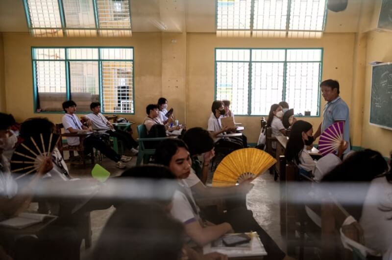 18日菲律賓高中生一邊搧扇子一邊上課。（路透社）