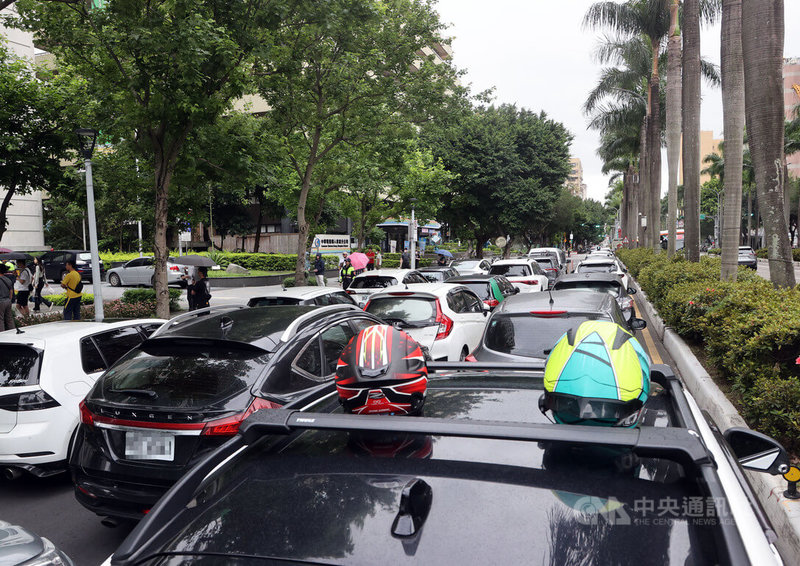 路權團體爭取機車路權,1日號召群眾到交通部前集結,以行動爭取「道路解嚴」,訴求讓大型重機行駛高速公路、廢除禁行機車條款等,現場不少人開著汽車到場響應,在車頂放置安全帽表達立場。中央社記者郭日曉攝 113年5月1日
