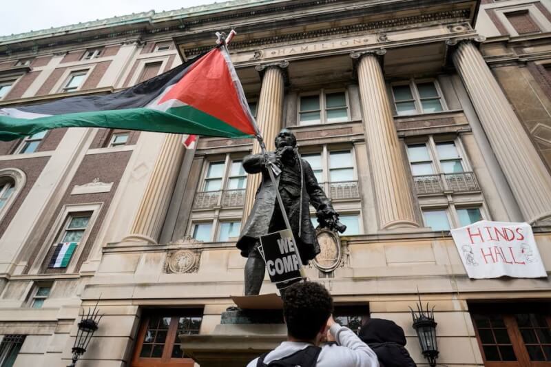 哥倫比亞大學示威者30日占領校區內的漢密爾頓大樓，校舍雕像被放上巴勒斯坦旗幟。（路透社）