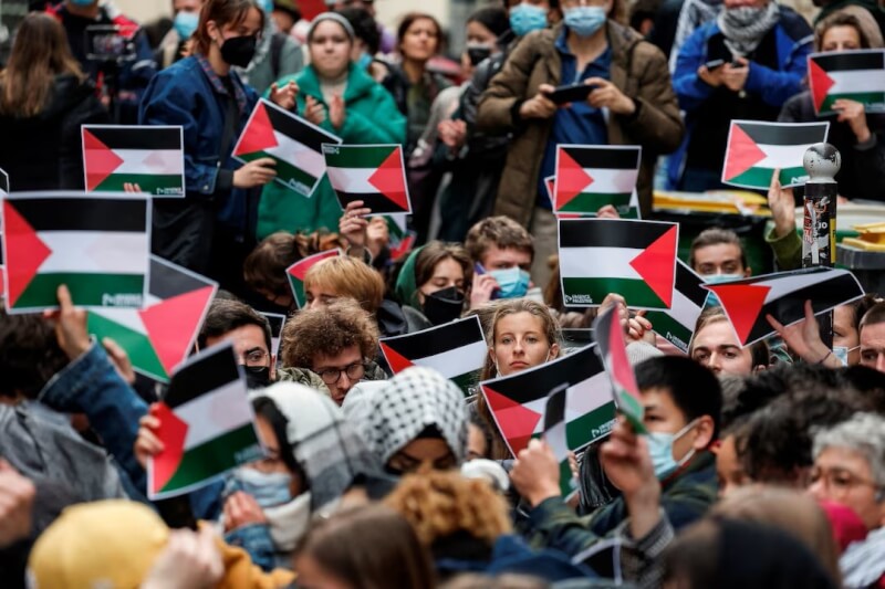 法國年輕人4月26日聚集在巴黎政治學院前，手持巴勒斯坦國旗表達反戰訴求。（路透社）