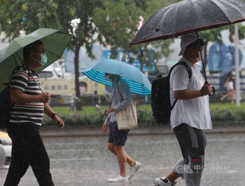 北市信義區民眾撐傘遮雨。（中央社檔案照片）