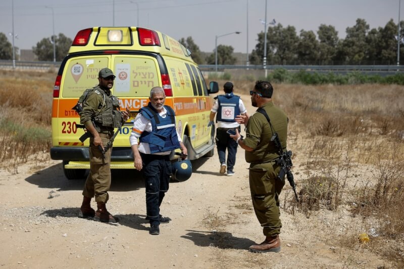 以色列南部的克瑞沙洛邊界關卡遭到火箭攻擊。圖為攻擊後，以色列軍人和醫護人員走近一輛救護車。（路透社）
