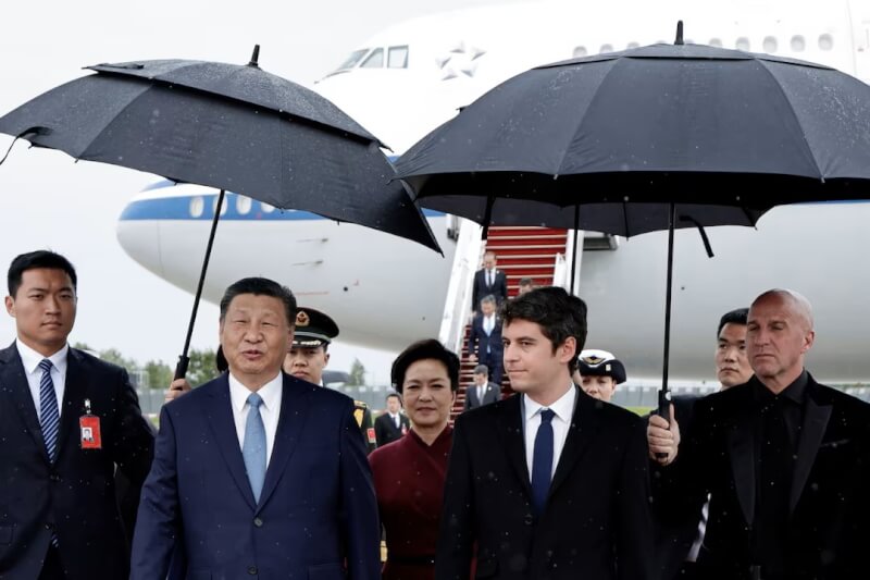 中國國家主席習近平（前左）5日抵達法國時與法國總理艾塔爾（前右）交談。（路透社）