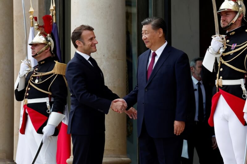 法國總統馬克宏（左2）在艾里賽宮和中國國家主席習近平（右2）握手致意。（路透社）