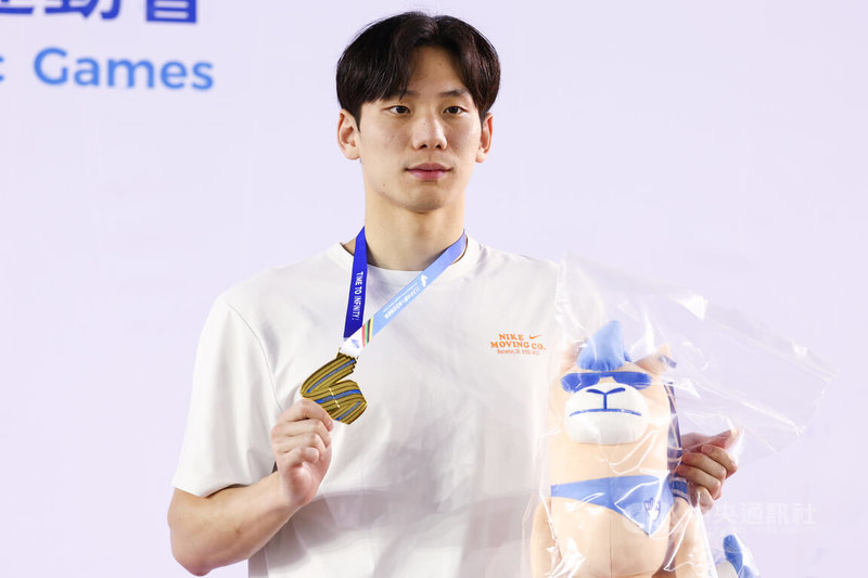 113年全大運公開男生組游泳200公尺蝶式決賽6日下午在台中市北區運動中心登場,代表台灣師大出賽的王冠閎(圖)以1分58秒23摘金,賽後開心與獎牌合影。中央社記者王騰毅攝 113年5月6日
