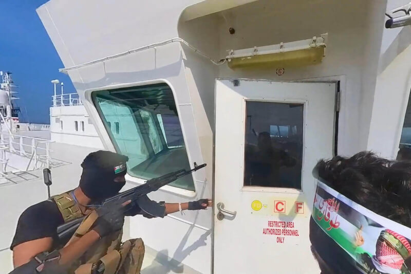 圖為11月20日一名「青年運動」士兵站在行經紅海的貨船上。(Houthi Military Media/Handout via 路透社)