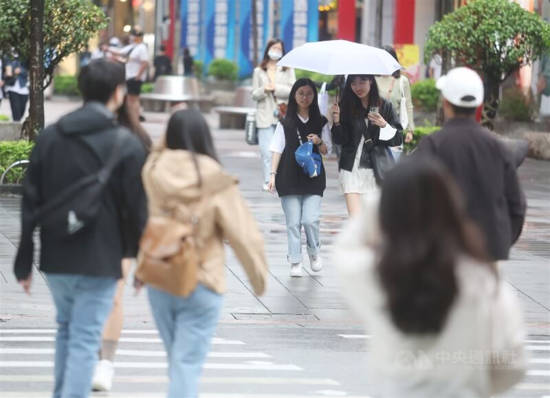 台北市信義區部分民眾撐傘走在街頭。（中央社檔案照片）