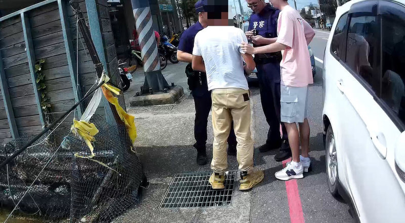 苗栗縣汪姓男子聽信投資理財群組宣稱可代操股票獲取高利潤,領取新台幣50萬元準備交付,巡邏員警察覺有異及時攔阻,並逮捕26歲許姓取款車手(白衣者)。(警方提供)中央社記者管瑞平傳真 113年5月7日