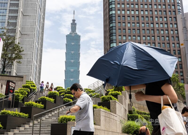 圖為台北市信義區民眾撐傘遮陽。（中央社檔案照片）