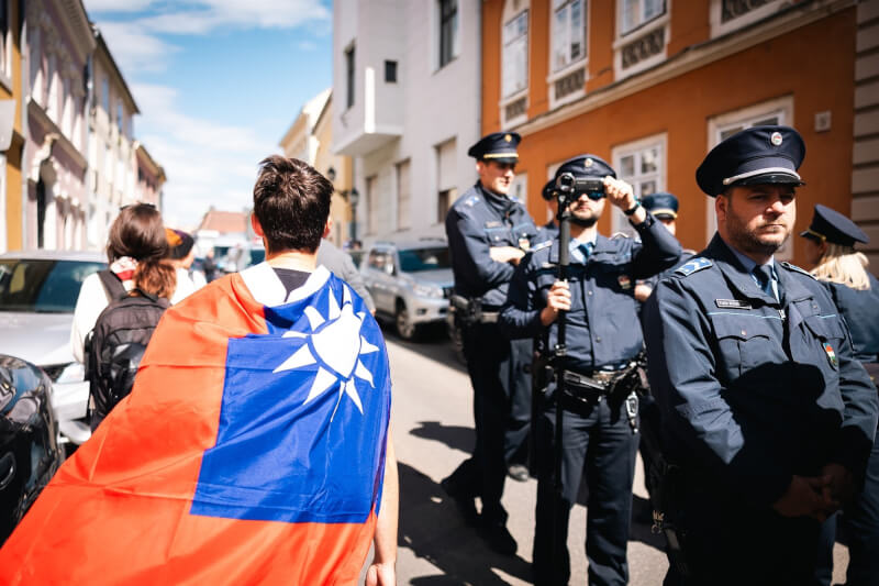 習近平訪匈牙利,身披台灣國旗的民眾在布達城堡抗議,大批警力駐守在旁。(圖取自facebook.com/TomposM)