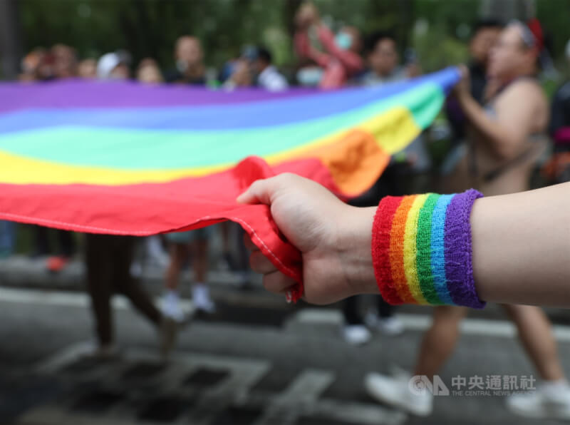 圖為2023年同志遊行，隊伍中許多人一同手持巨幅彩虹旗前行。（中央社檔案照片）