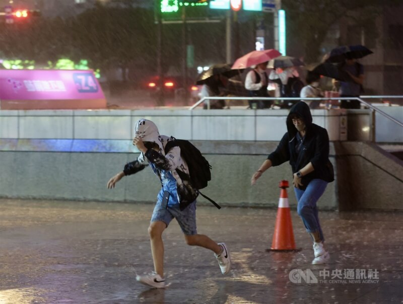 图为没带雨具的民众在台北车站附近快步躲避雨势。（中央社档案照片）
