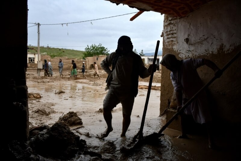 阿富汗北部巴格蘭省民眾11日忙著清理遭洪患造成的爛泥與積淹水。（法新社）