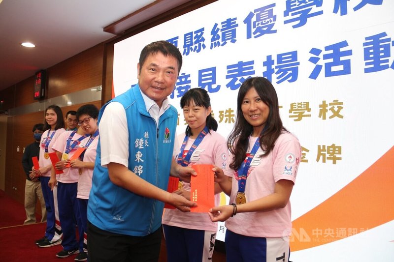 國立苗栗特殊教育學校啦啦隊在2024世界啦啦隊錦標賽一舉奪金,13日接受縣長鍾東錦(前左)表揚頒發獎勵金;總教練簡孟瑩(右)感動表示,「他們總是掛著笑容開開心心來練習,這是身為老師的福氣」。中央社記者管瑞平攝 113年5月13日