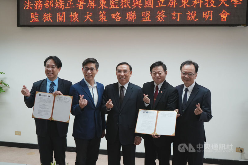 法務部矯正署屏東監獄14日與國立屏東科技大學簽訂策略聯盟備忘錄,合作推動「監獄關懷犬」計畫,由屏東科大校長張金龍(左1)、屏東監獄典獄長蔡景裕(右1)代表簽署,民進黨立委鍾佳濱(左2)與法務部長蔡清祥(中)見證。中央社記者黃郁菁攝 113年5月14日
