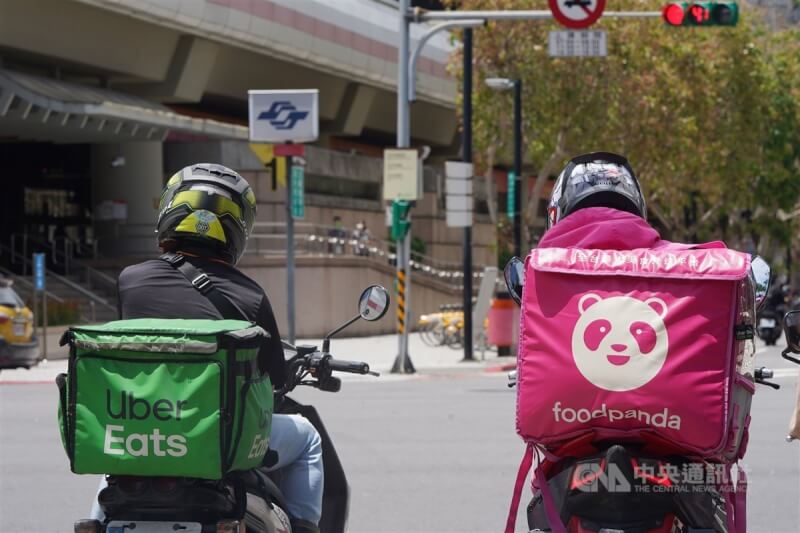 Uber Eats、foodpanda外送員在台北市士林區街頭趕送單。（中央社檔案照片）