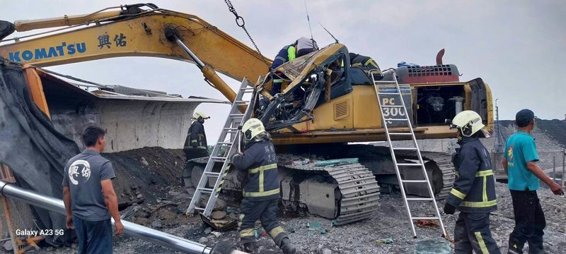 屏東鹽埔鄉豐年路14日發生一起工安意外，1名曳引車駕駛操作不當，車斗傾斜壓到旁邊怪手，導致怪手駕駛艙嚴重變形，警消協助怪手司機脫困並送醫。（屏東縣政府消防局提供）中央社記者黃郁菁傳真  113年5月14日