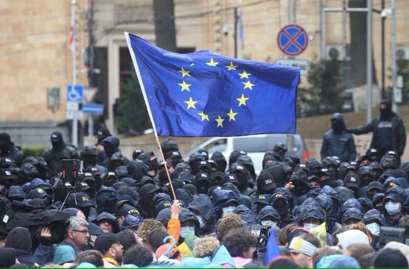喬治亞示威民眾14日在特比利西街頭手舉歐盟旗幟，抗議境外影響力法案。（路透社）