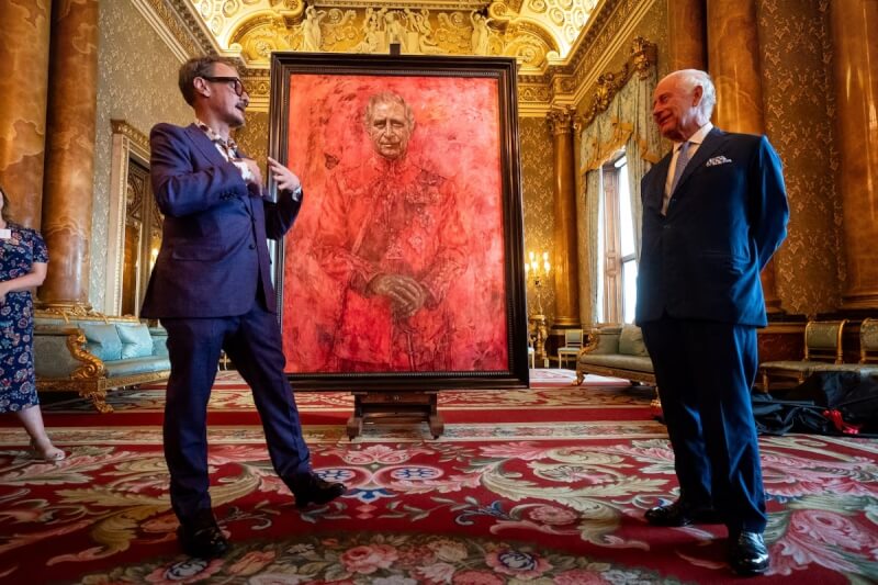 英國國王查爾斯三世（右）在肖像畫前會見藝術家伊歐（左）。（路透社）