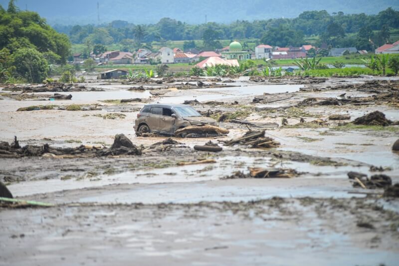 印尼西蘇門答臘省下豪雨引發洪災。圖為12日一輛受損的汽車困在泥流中。（路透社）