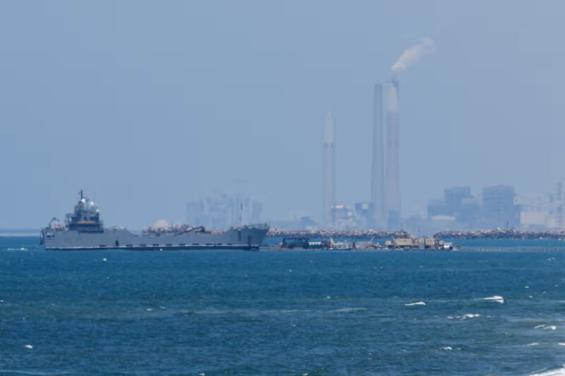 美軍16日將臨時浮動碼頭固定在加薩走廊海灘上。（路透社）