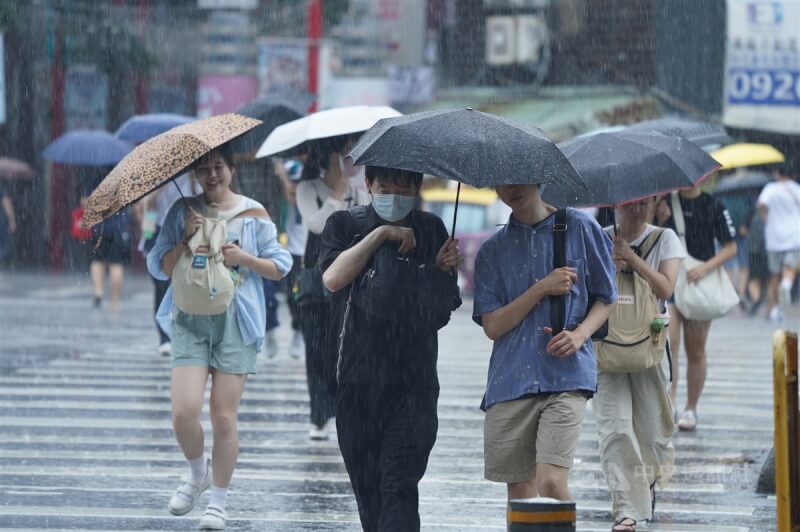 民眾在台北市中正區撐傘過馬路。（中央社檔案照片）