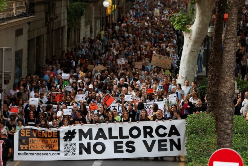 數以千計西班牙民眾25日在熱門旅遊景點巴利亞利群島示威，對爆量的觀光人潮說不。（路透社）
