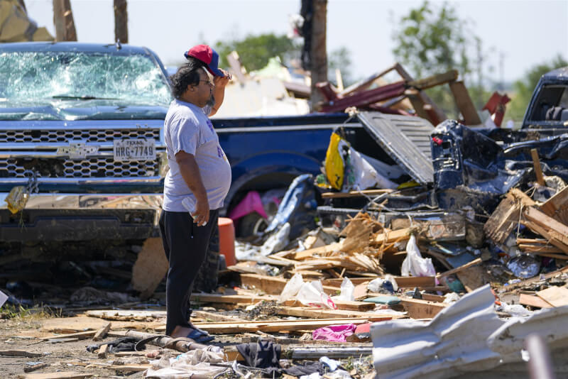 龍捲風和極端風暴肆虐美國中部，一名男子26日在德州谷景地區望向被摧殘後的景象。（美聯社）