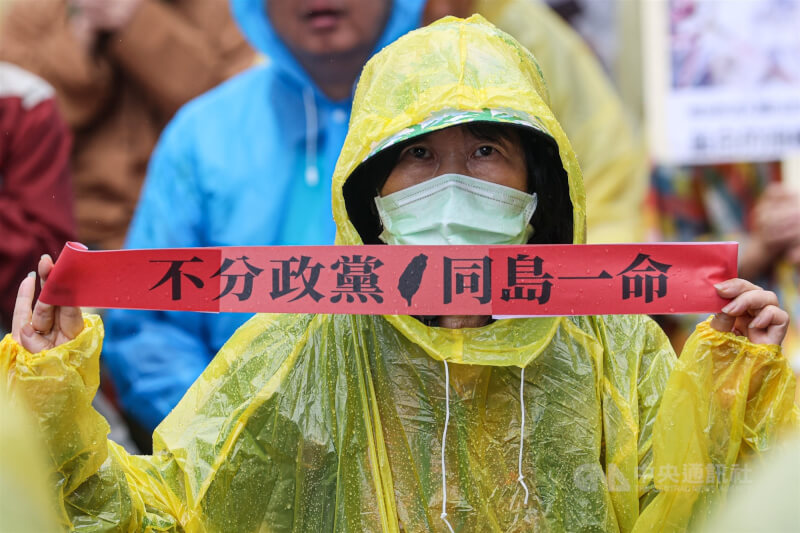 立法院28日續審國會職權法案，場外雨勢不斷，民眾身穿雨衣持標語「不分政黨 同島一命」，表達訴求。中央社記者鄭清元攝 113年5月28日