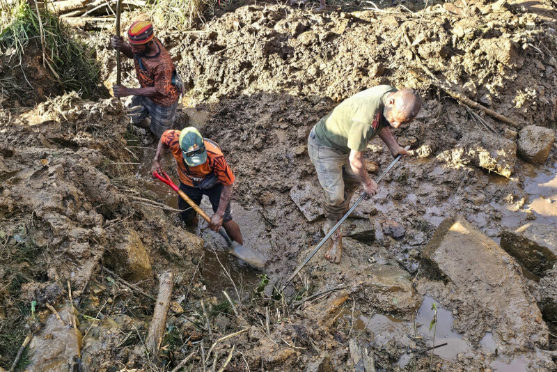 巴布亞紐幾內亞大規模山崩摧毀一處偏遠高地社區，當地民眾27日使用鏟子和挖土棒試圖找到生還者。（法新社）