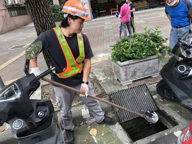 新北市環保局表示,清潔隊112年獲報有596件物品掉進水溝,前5名是鑰匙、藍牙耳機、手機、卡片類及戒指。圖為清潔隊員協助民眾從水溝中撈出鑰匙。(新北市環保局提供)中央社記者高華謙傳真 113年6月3日