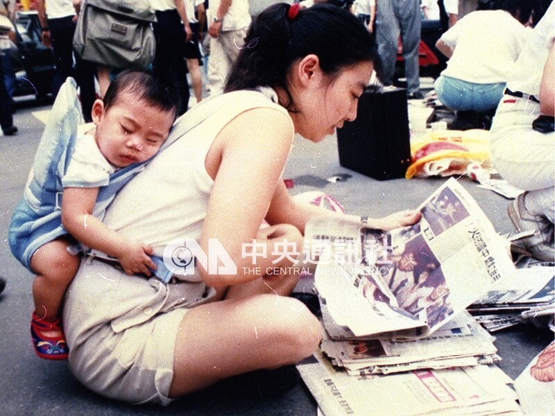 一名女性背著小孩擔任義工。中央社記者方沛清攝 78年6月6日