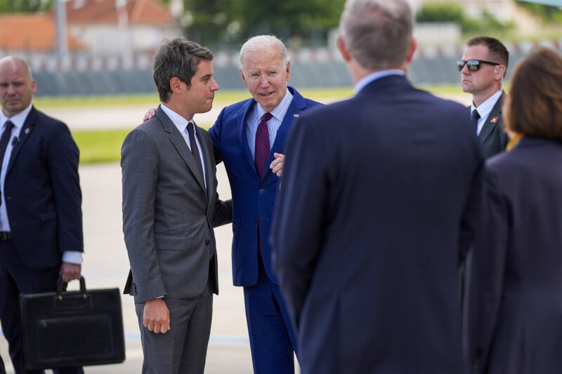 美國總統拜登（中右）5日抵達法國，與法國總理艾塔爾（中左）交談。（美聯社）