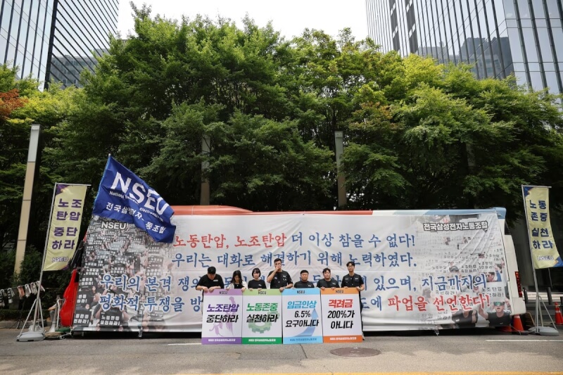 三星電子員工7日在公司大樓前舉牌抗議。（路透社）