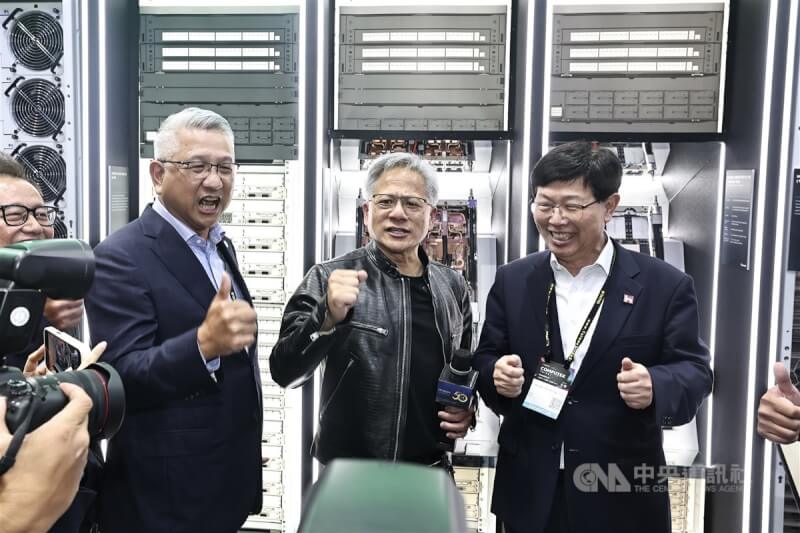輝達(NVIDIA)執行長黃仁勳(中)4日在2024台北國際電腦展(COMPUTEX 2024)參訪鴻佰攤位,與鴻海董事長劉揚偉(右)互動、喊話。中央社記者翁睿坤攝 113年6月4日