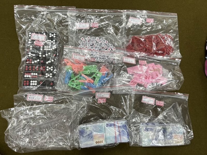 高雄市大社區一處鐵皮屋10日凌晨擺設天九牌賭桌,聚集超過50名賭客及工作人員,警方現場查扣抽頭金1萬6000元、賭資現金20萬2000元、賭具膠質天九牌、骰子、押寶盒等證物。(高雄市警察局仁武分局提供)中央社記者張已亷傳真 113年6月10日